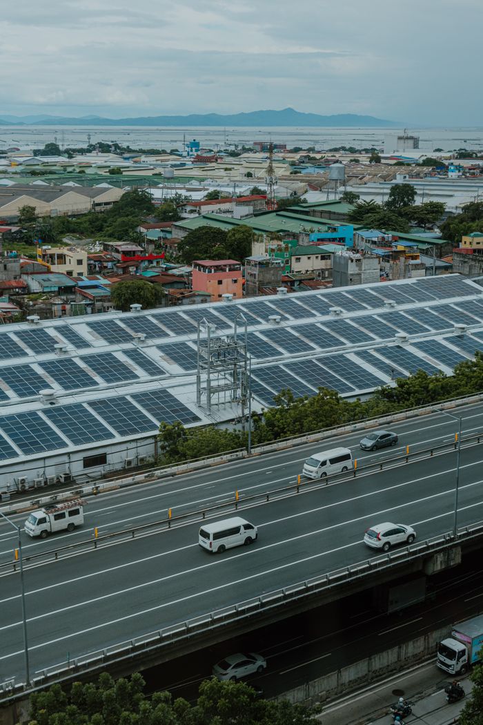 Urban landscape with solar panels and highway, showcasing renewable energy and modern infrastructure.