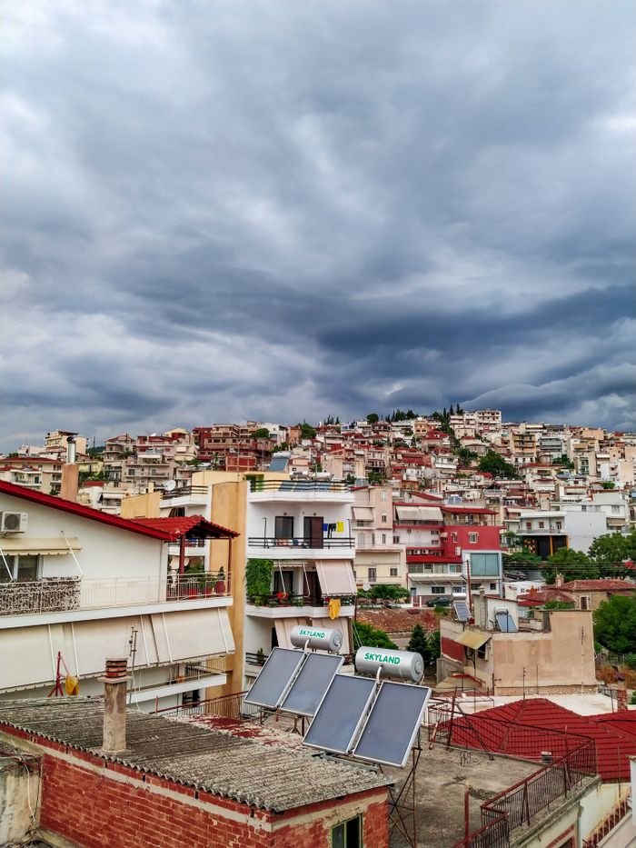 Vibrant urban cityscape of Lamia, Greece showcasing colorful homes and stormy skies.