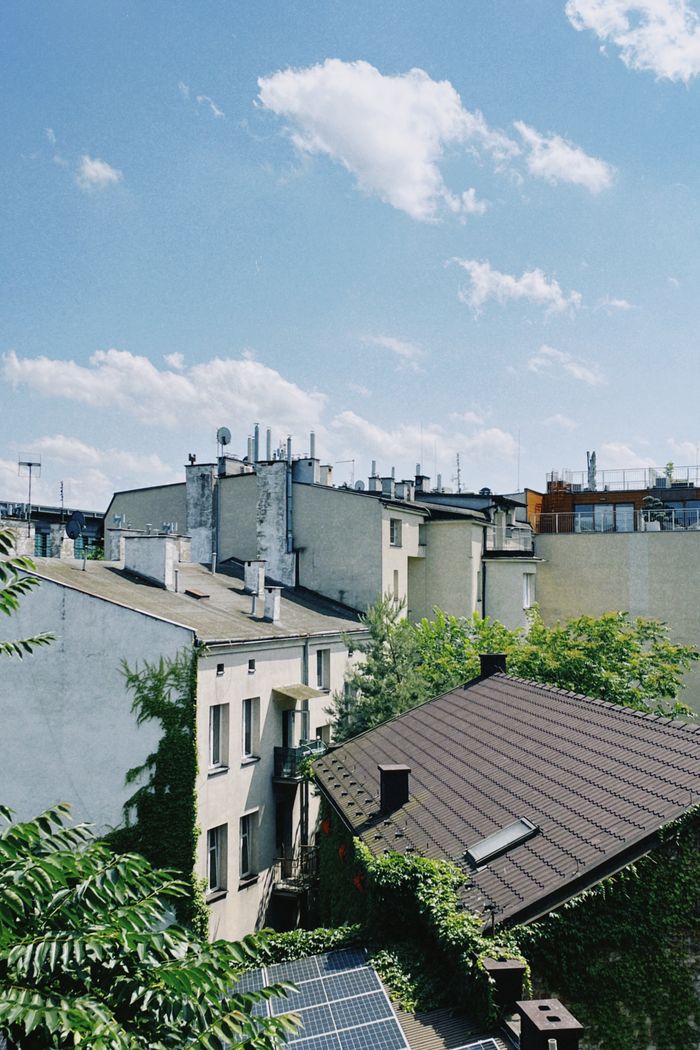 A sunny view of Kraków rooftops featuring residential buildings and solar panels.